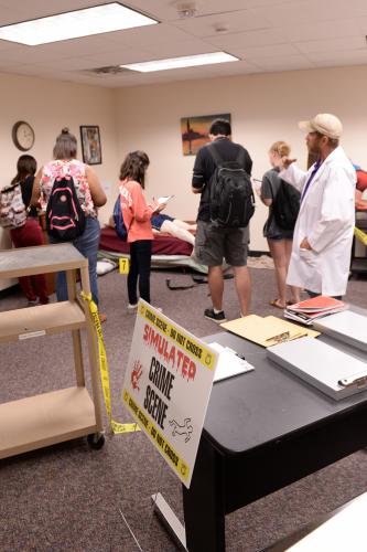Groups of high school students analyzed a mock crime scene during the Stephen F. Austin State University Pre-Law Academy crime scene investigation simulation led by Dr. Milton Hill, SFA assistant professor in the Department of Government.