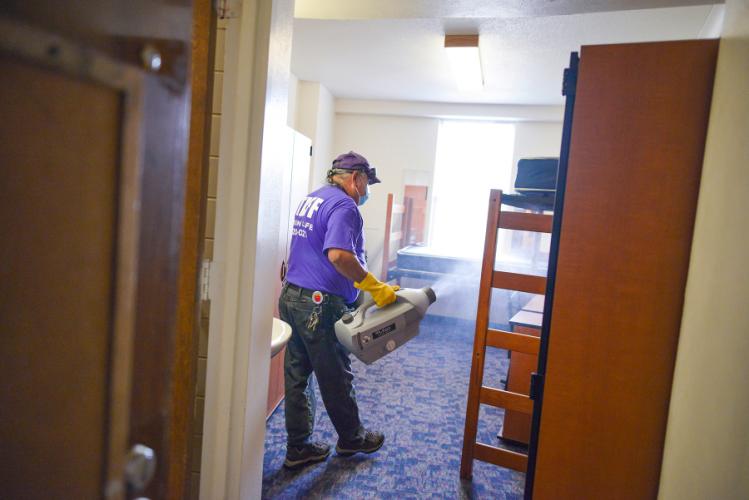 J.R. Florez, an employee with Stephen F. Austin State University’s Residence Life Department, mists a room in Steen Hall with a hypochlorous acid