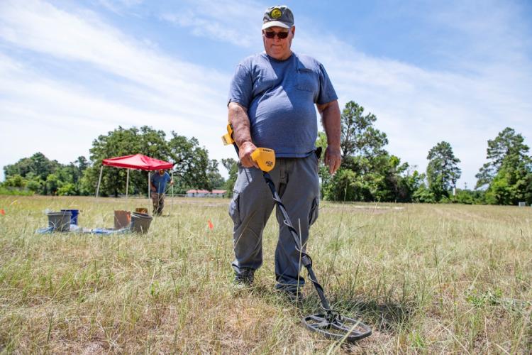 volunteer John Jefferson using a metal detector to canvas where the Sand Hill community school was believed to be located