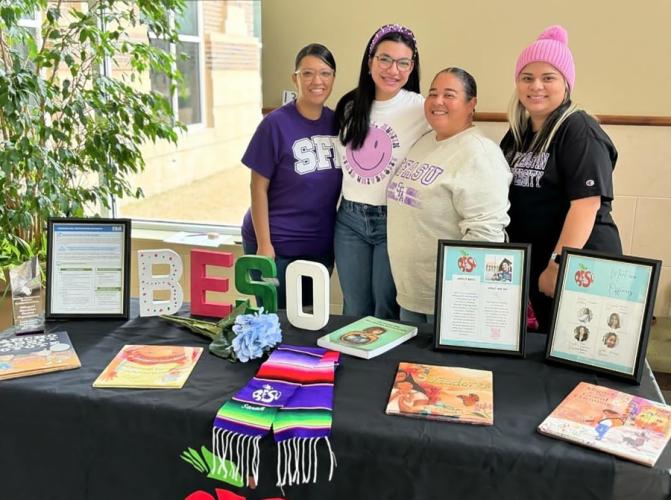 Members of SFA's BESO chapter stand behind a table featuring books and other BESO materials