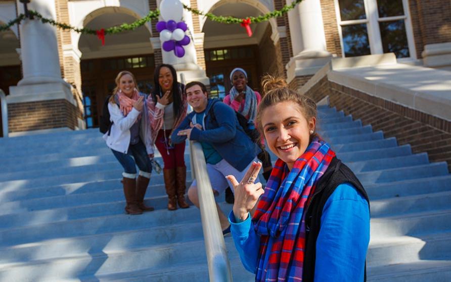 SFA students showing the SFA hand sign