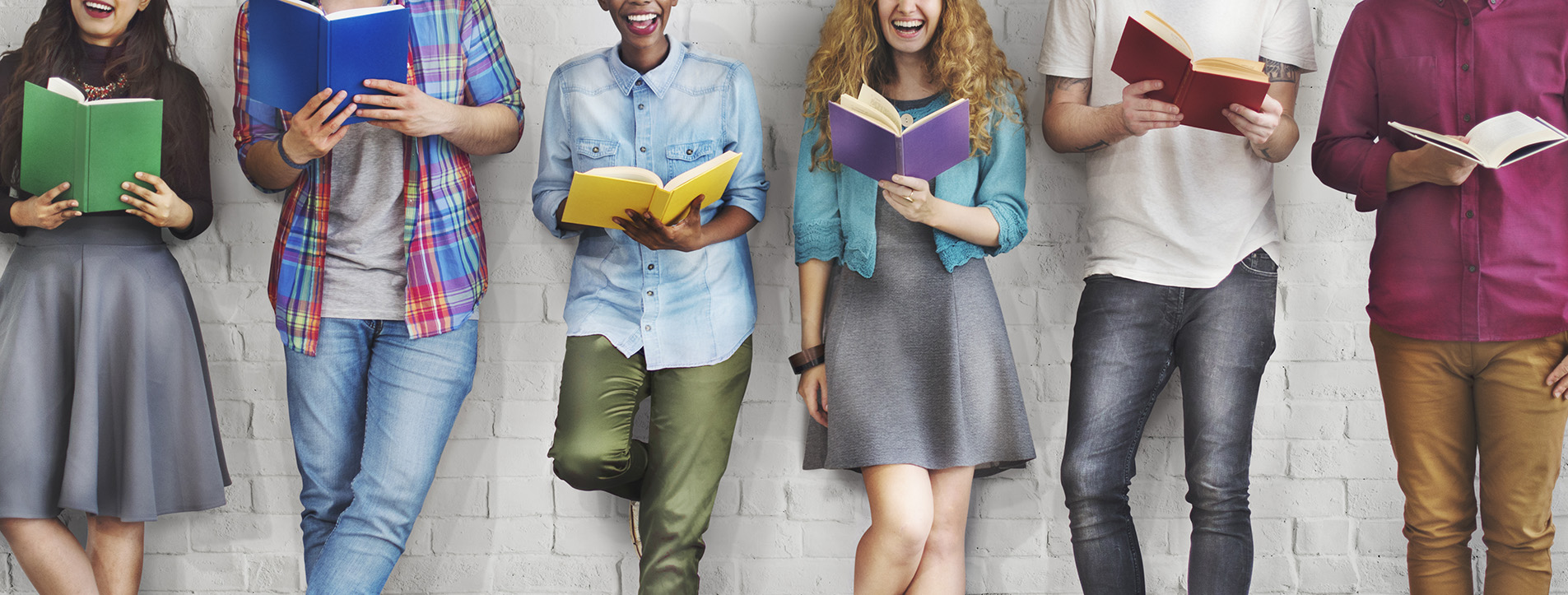 Students from neck down wearing different clothing styles and reading books