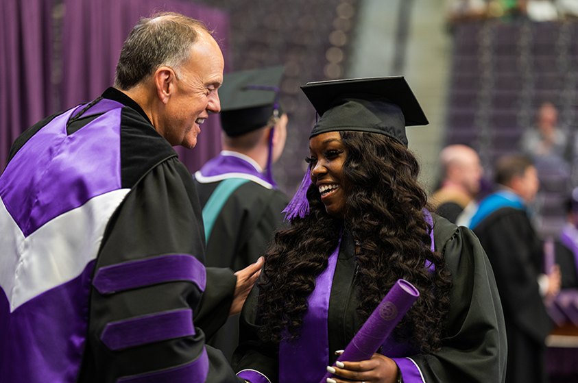 Steve Westbrook congratulating a graduate student at commencement