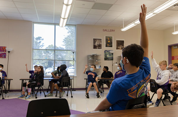 Charter classroom with kid raising hand