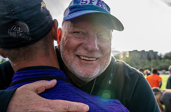 Coach Phil Olson hugging person