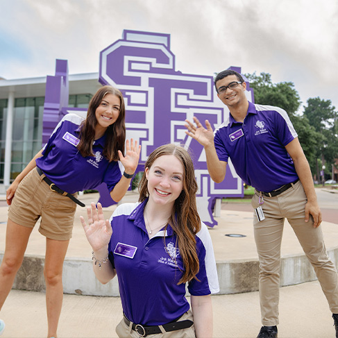 Students posing by SFA statue