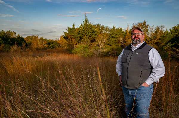 Dr. Roel Lopez standing in a field