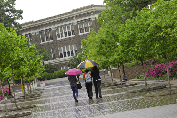 students walking under umbrellas