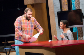 Two students prepare a broadcast together in a studio