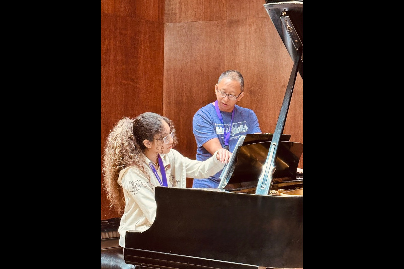 A student works with a faculty pianist