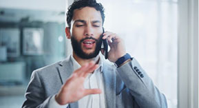 man talking on a cellphone trying to calm the person down on the other end of the phone