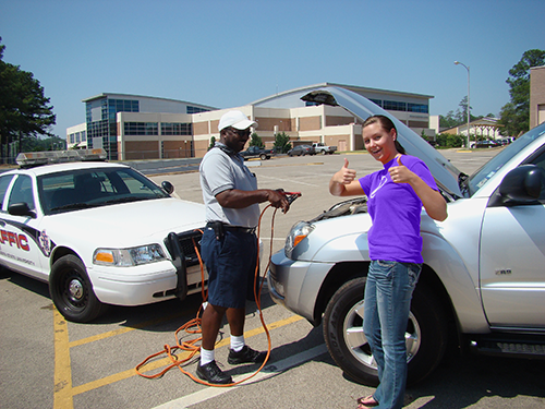 UPD officer helping jump-start a student's vehicle.