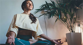 woman meditating with her eyes closed, smiling