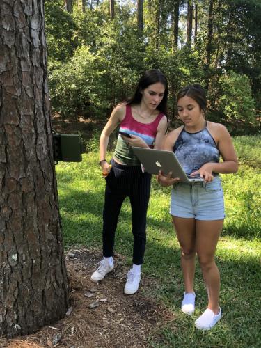 Lufkin High School seniors Sarah Riley and Kennedy Tinajero examine data from a Song Meter