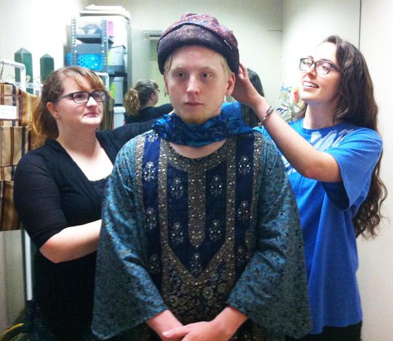 Kathleen Easterling , assistant costume designer, and Cloey Hammonds, costume assistant, work on fitting a costume for Greg Albright