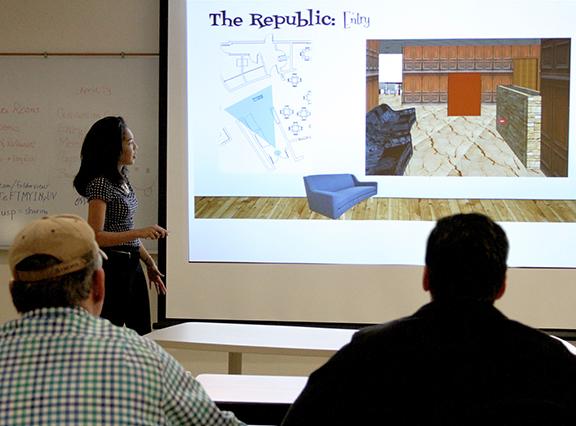 Stephen F. Austin State University senior Nia Ledger presents her group's design concepts for The Fredonia Hotel to hotel owner Richard DeWitt and hotel management.