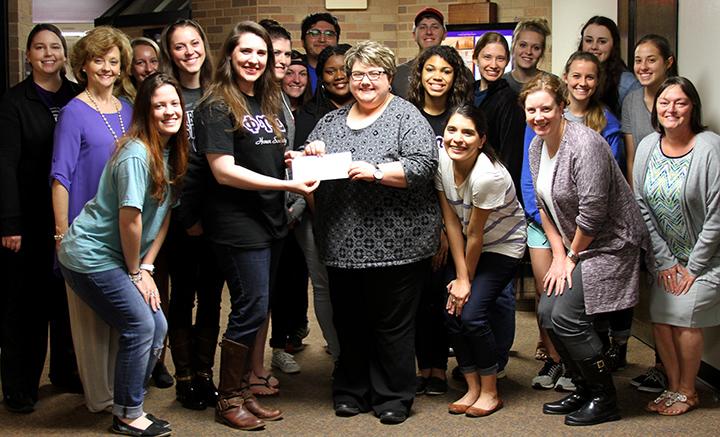 photo of Phi Upsilon Omicron members presenting proceeds to Robin Johnson