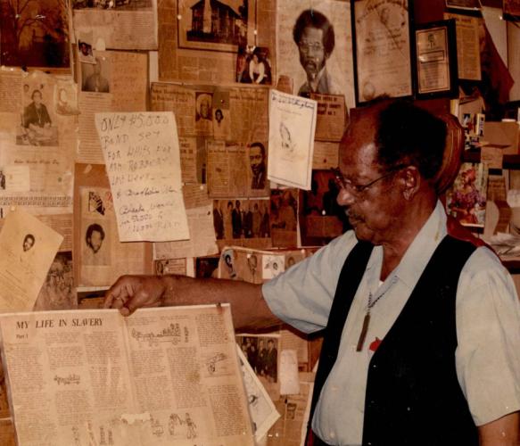 a photo of Nacogdoches leader the late Arthur Weaver holding up one of dozens of newspaper articles and clippings he saved during his decades-long fight advocating for civil rights