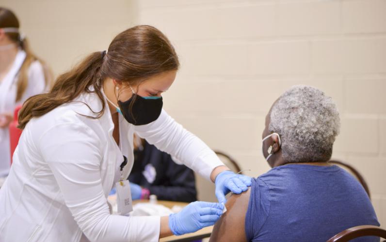 An SFA nursing student administers a dose of the Moderna vaccine.
