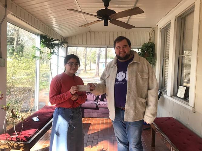 Mu Phi Epsilon member Cole Jones presents the check donation to Music Prep student violinist Sabrina Flores
