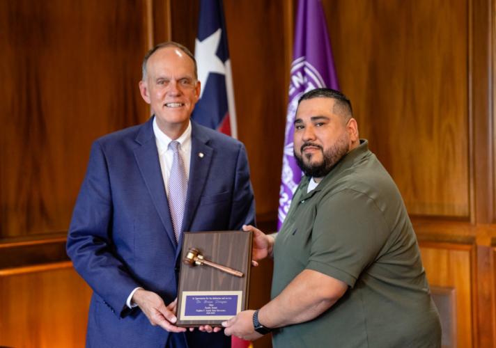 Dr. Steve Westbrook presents a plaque to Dr. Brian Uriegas.