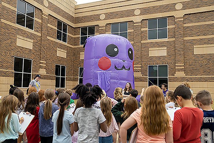 Students surround a large Pikachu inflatable 
