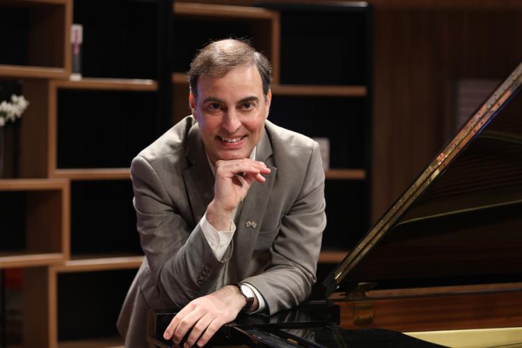 Aviram Reichert sits behind a piano