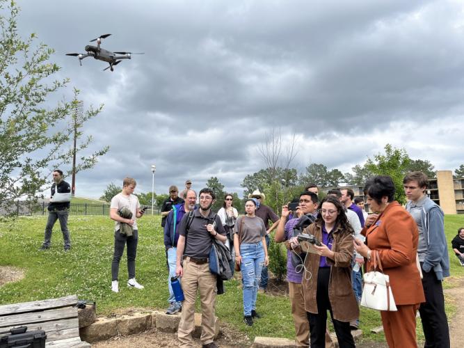 A drone flies above students during a demonstration