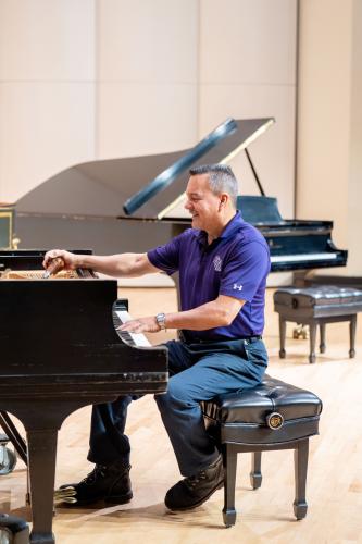 Paco Morales tuning one of the grand pianos in the School of Music