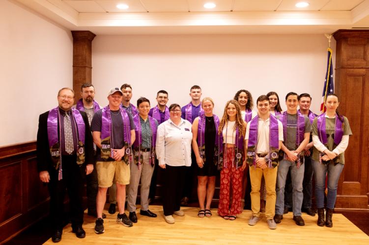 Fifteen veterans, those currently in active duty, reservists, members of the U.S. National Guard and those commissioned in ROTC pose with their regalia during Stephen F. Austin State University’s inaugural Veterans Resource Center graduation luncheon May 3.