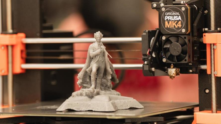 Close-up of a 3D printer creating a small statue of Stephen F. Austin