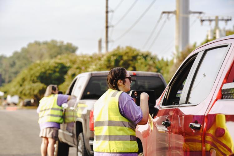 A volunteer provides parking instructions to an SFA student during move-in weekend.