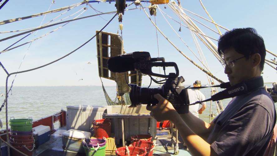 Filmmaker Tim Tsai shoots on the deck of Captain Ron Galloway's boat in the filming of “Seadrift.”