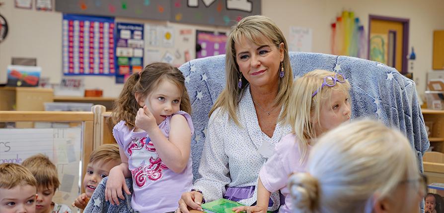 Former teacher and current SFA first lady Kristi Weaver reads "The Giving Tree" to children ages 4 to 6 at the SFA Charter School. Photo by Lizeth Garcia