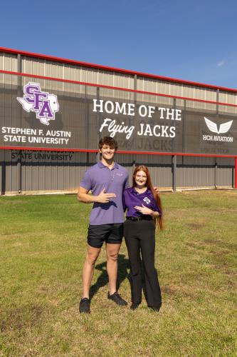 Johnna Edwards and Sayer Swinford standing outside the SFA aircraft hangar
