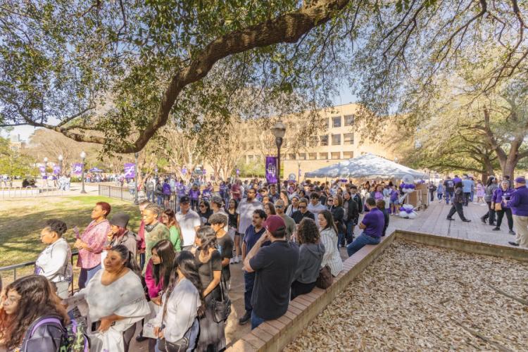 Parents and students gather outside to participate in Showcase Saturday. Purples SFA banners, balloons and tents are shown in the background.