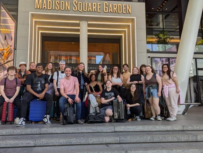 Students from SFA's School of Theatre and Dance pose for a photo in front of a building with Madison State Garden lettering