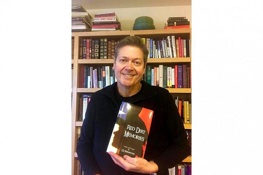 Jerry Permenter holding his "Red Dirt Memories" book