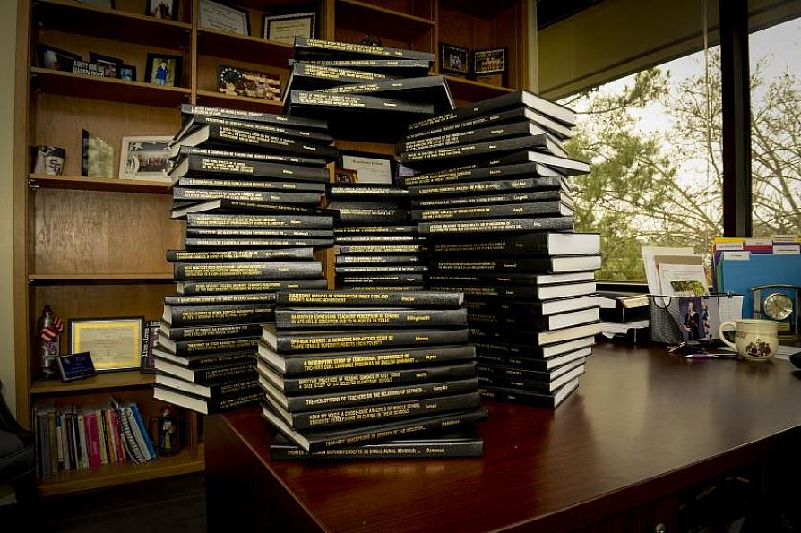 a collection of theses and dissertations on a desk