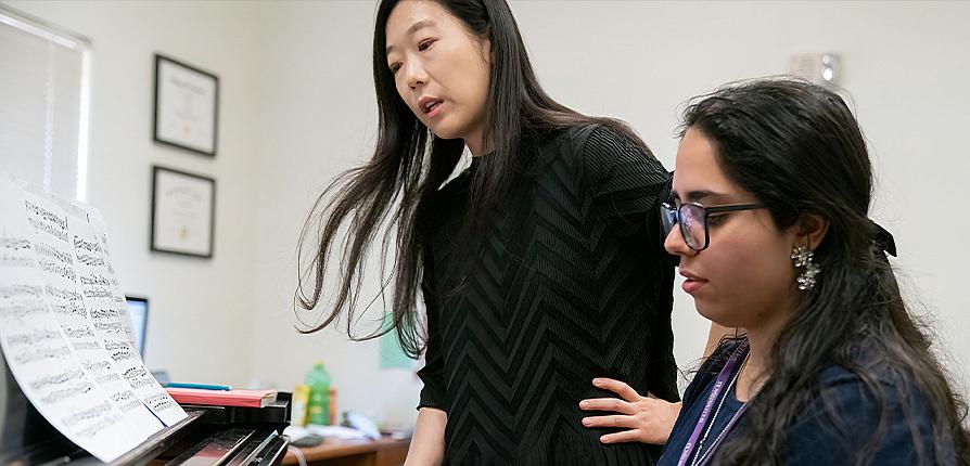 Instructor and student playing piano