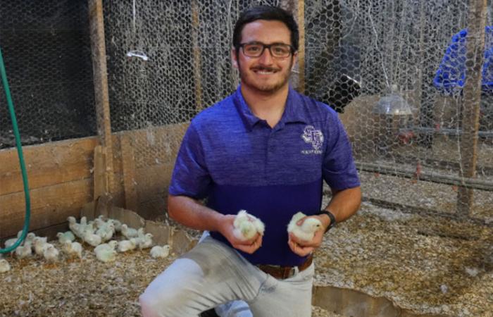 A photo of a student holding baby chicks