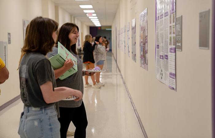 Department of Education Studies Undergraduate Research Symposium, symposium participants review student Anna Ashy’s “Honors Contract – Kolb’s Experiential Learning at Caddo Lake State Park: TEKS-aligned Interpretative Tours.”