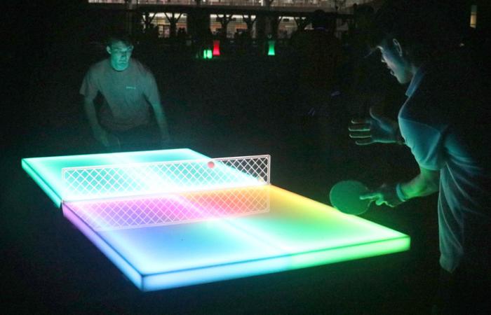 Students playing glow in the dark table tennis